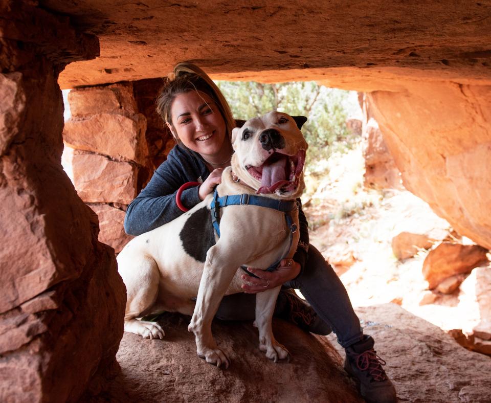 Person hiking with a dog in red rocks in southern Utah