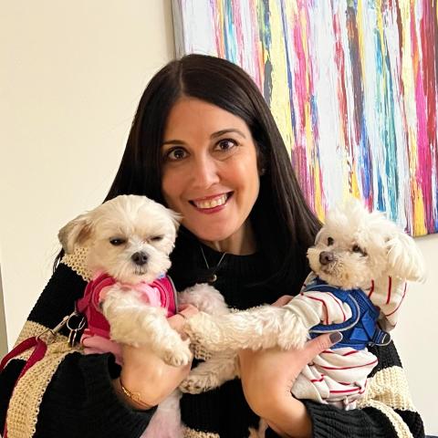 Alina Hauptman holding two small white dogs