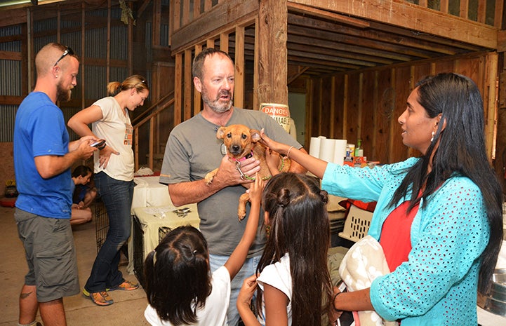 Here, Best Friends staff member Matt Fisher introduces puppy, Paige, to her new foster family