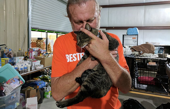 Best Friends staff member Mike Bzdewka snuggles a cat at the Rescue and Reunite Center