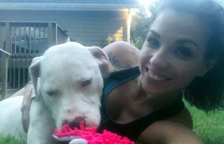 Selfie of woman lying on some grass next to Sailor the dog