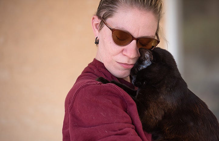 Woman and Ellery the cat in a hug