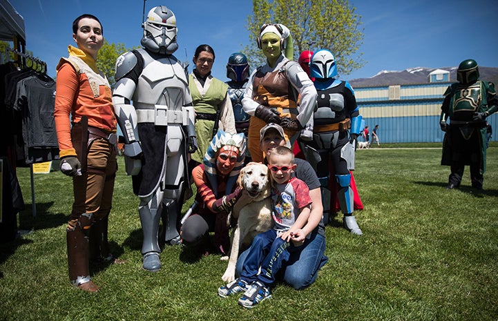 Family who adopted Keela the dog surrounded by many Star Wars characters at the May the 4th NKUT Super Adoption event