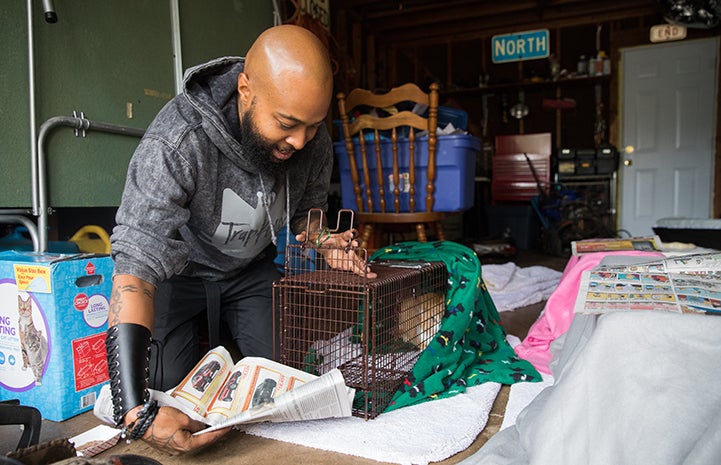 Sterling “Trap King” Davis inserting newspaper into a live trap