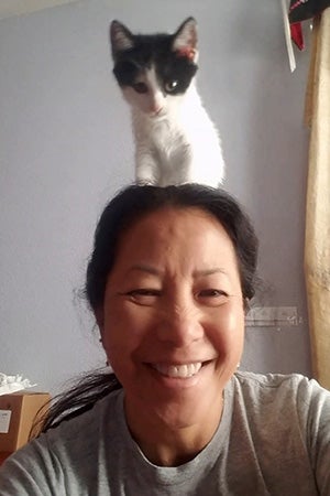 Volunteer Sophia Lim with a kitten on her head