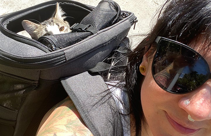Squeegee the cat in a backpack on Paula's back