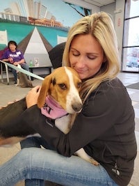 a dog behing hugged by new owner at the animal shelter