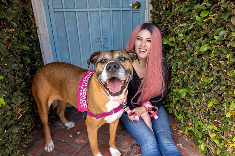 Woman sitting outside a doorway with her adopted dog