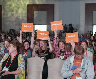 Conference attendees holding signs that say "Believe Together #NoKill2025"