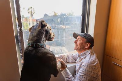 Bud the dog and one of his adopters looking out the window at the burned remains of a building