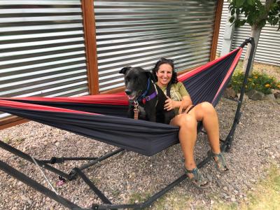 Danielle and Minnie the dog sitting together in a hammock