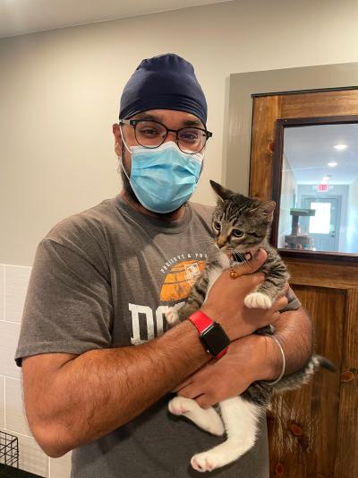 Ramandeep Singh wearing a mask and holding a cat
