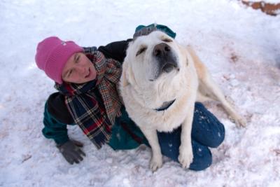 Klondike the dog being petted by a person outside in the snow
