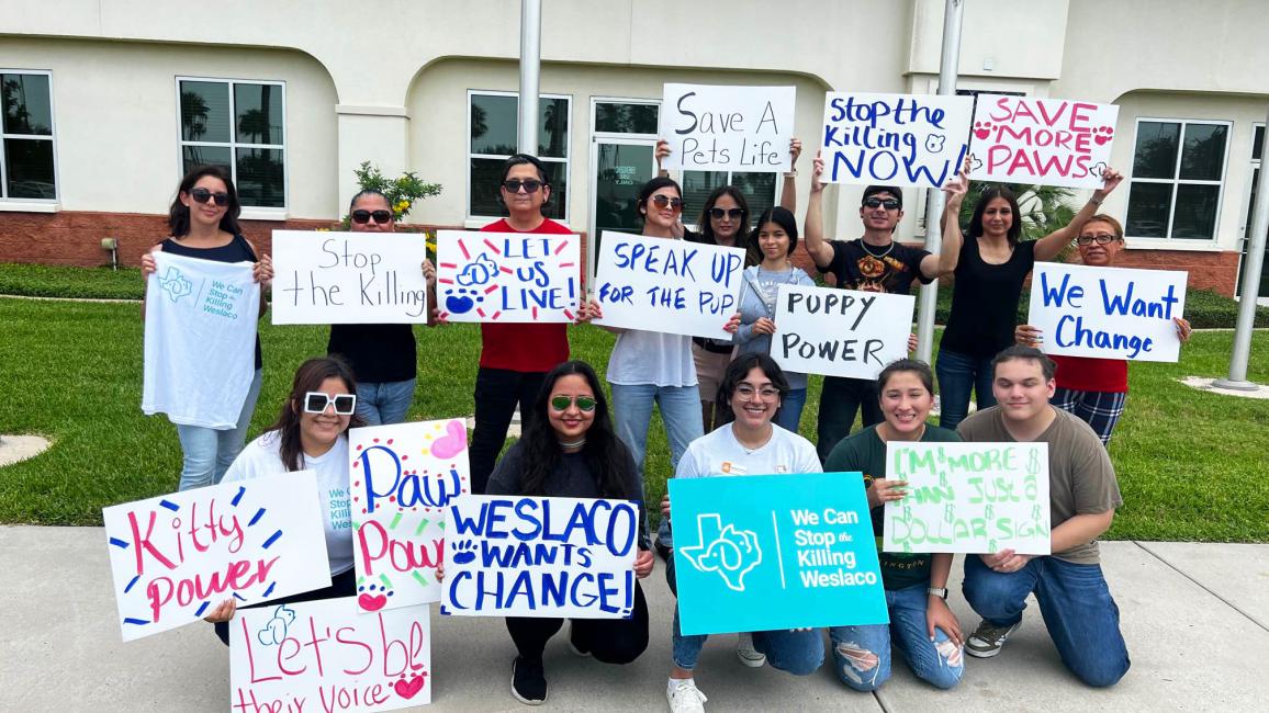 Group of people holding signs to celebrate Best Friends Day of Action in  Weslaco, Texas