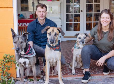 Peter the dog with his new family (including two other dogs), all on a front porch of a home
