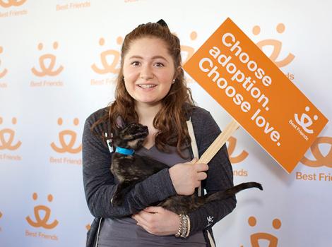 Emma Kenney holding a cat and a "Choose Adoption. Choose love." sign